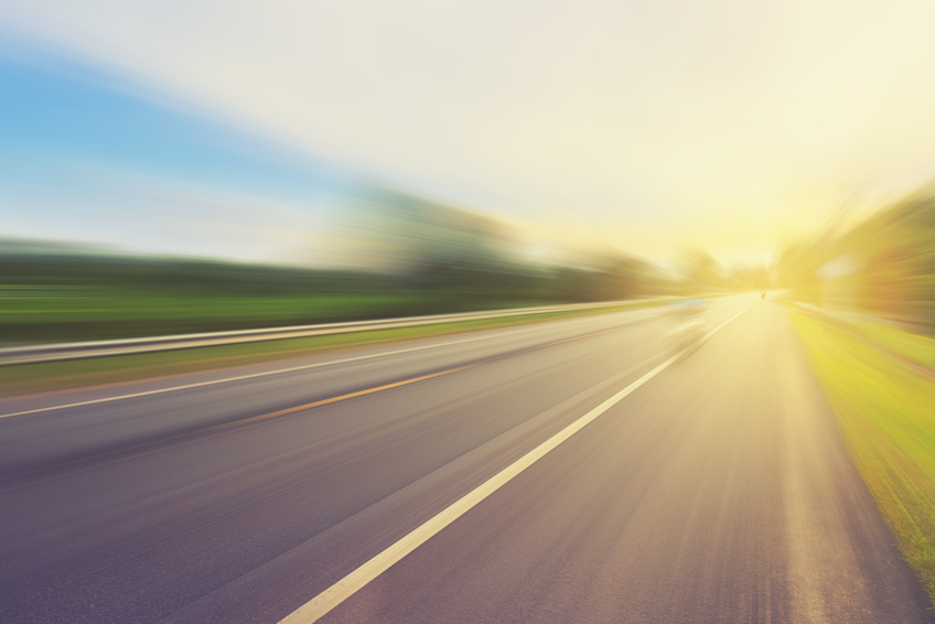 Empty asphalt road in motion blur and sunlight with vintage tone